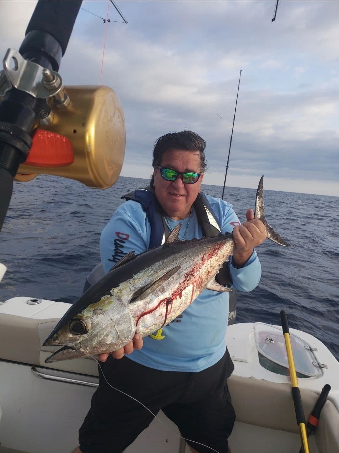 Angler holding a blackfin tuna offshore