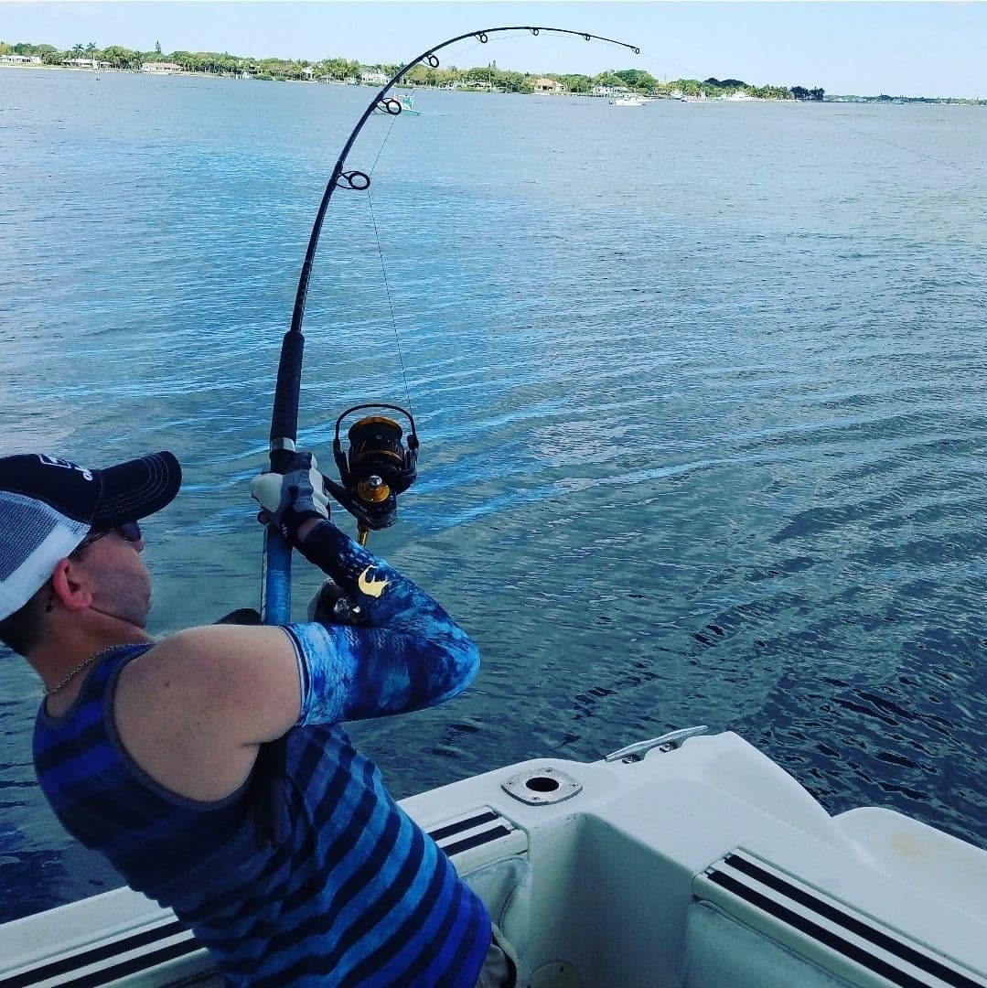 Angler fighting a fish from the boat on the river
